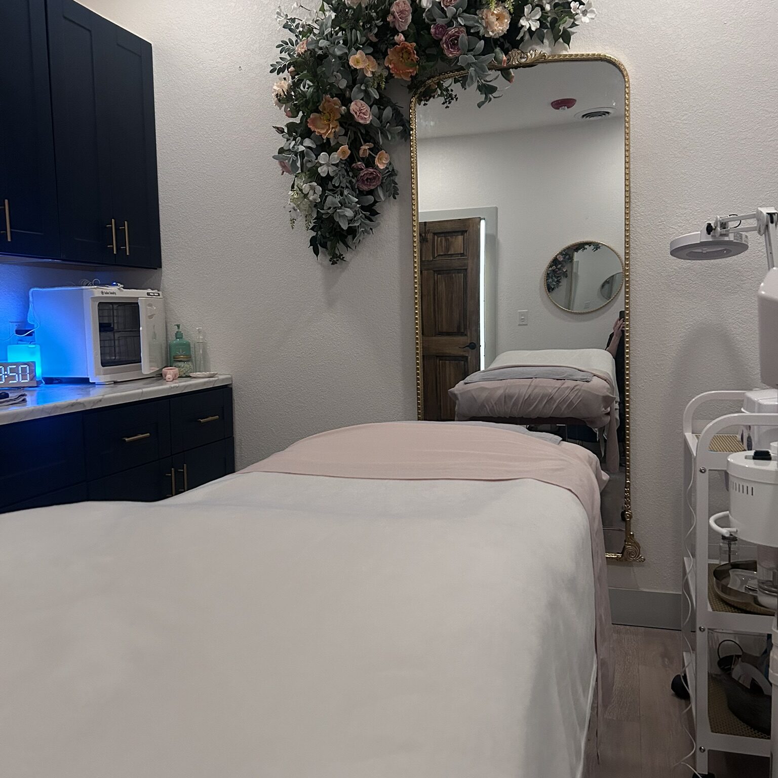 Esthetician room with mirror and floral arrangement